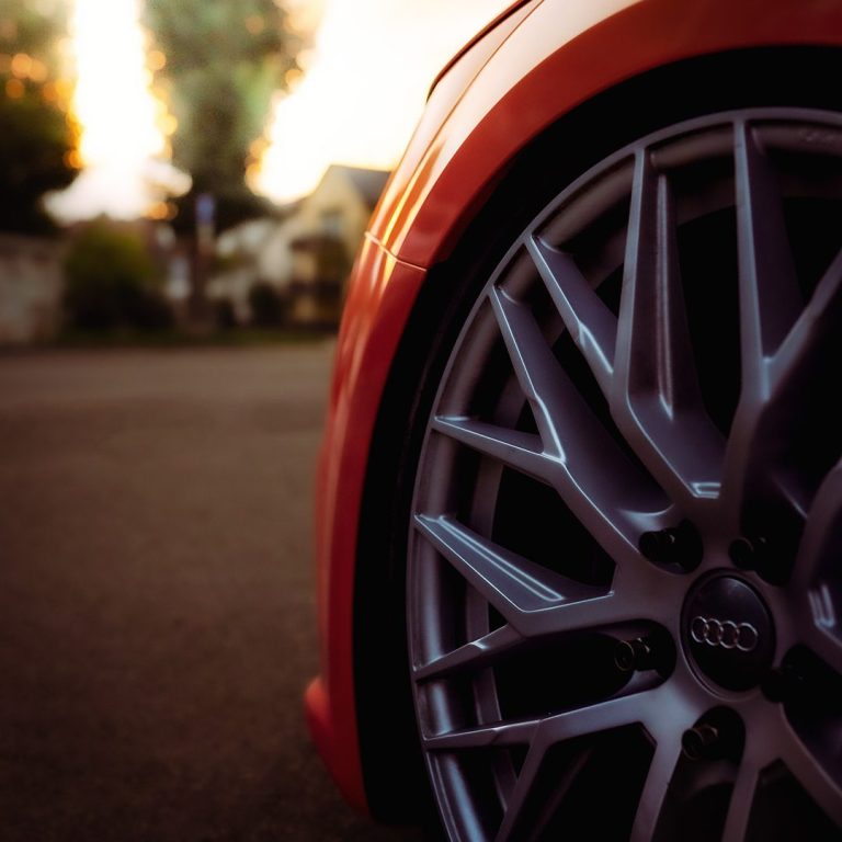 Eventfotografie Detailaufnahme eines einer Autofelge bei einem orangenen Auto.