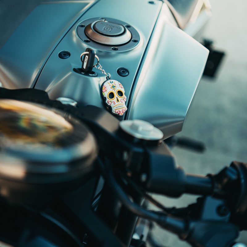 Nahaufnahme eines Motorrads mit einem Schlüsselanhänger in Form eines Schädels.